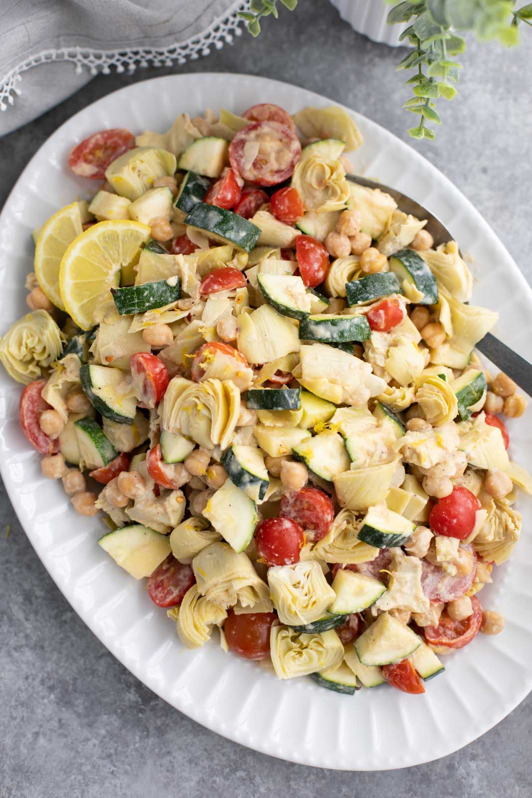 A large white platter filled with vegetables on a gray background. 